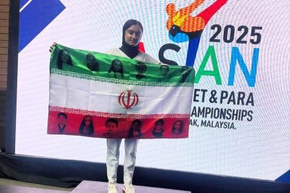 پرچم منقش به تصاویر شهدای ۱۲ روزه روی سکوی قهرمانی آسیا