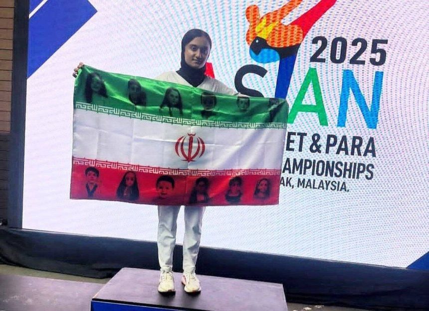 پرچم منقش به تصاویر شهدای ۱۲ روزه روی سکوی قهرمانی آسیا